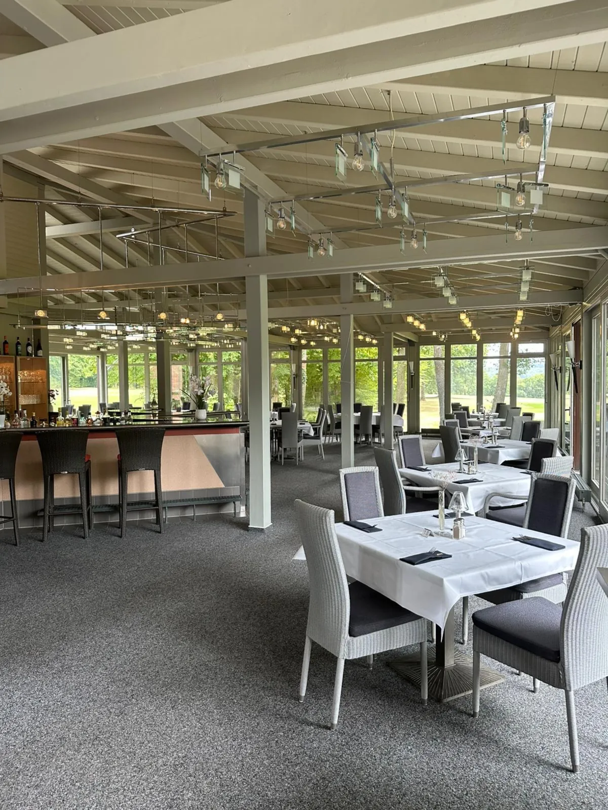 Innenraum des Restaurants mit Bar und gedeckten Tischen